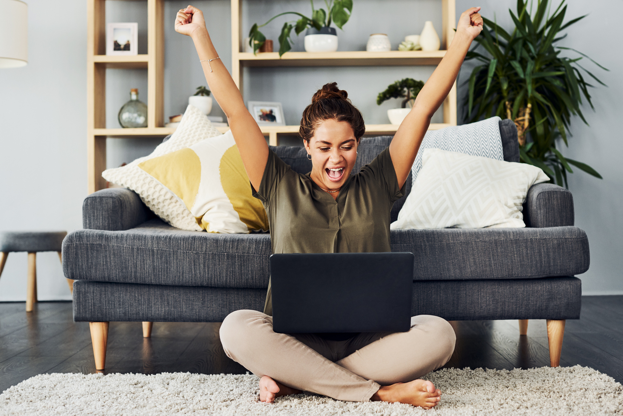Happy Woman with Laptop Celebrating Success at Home